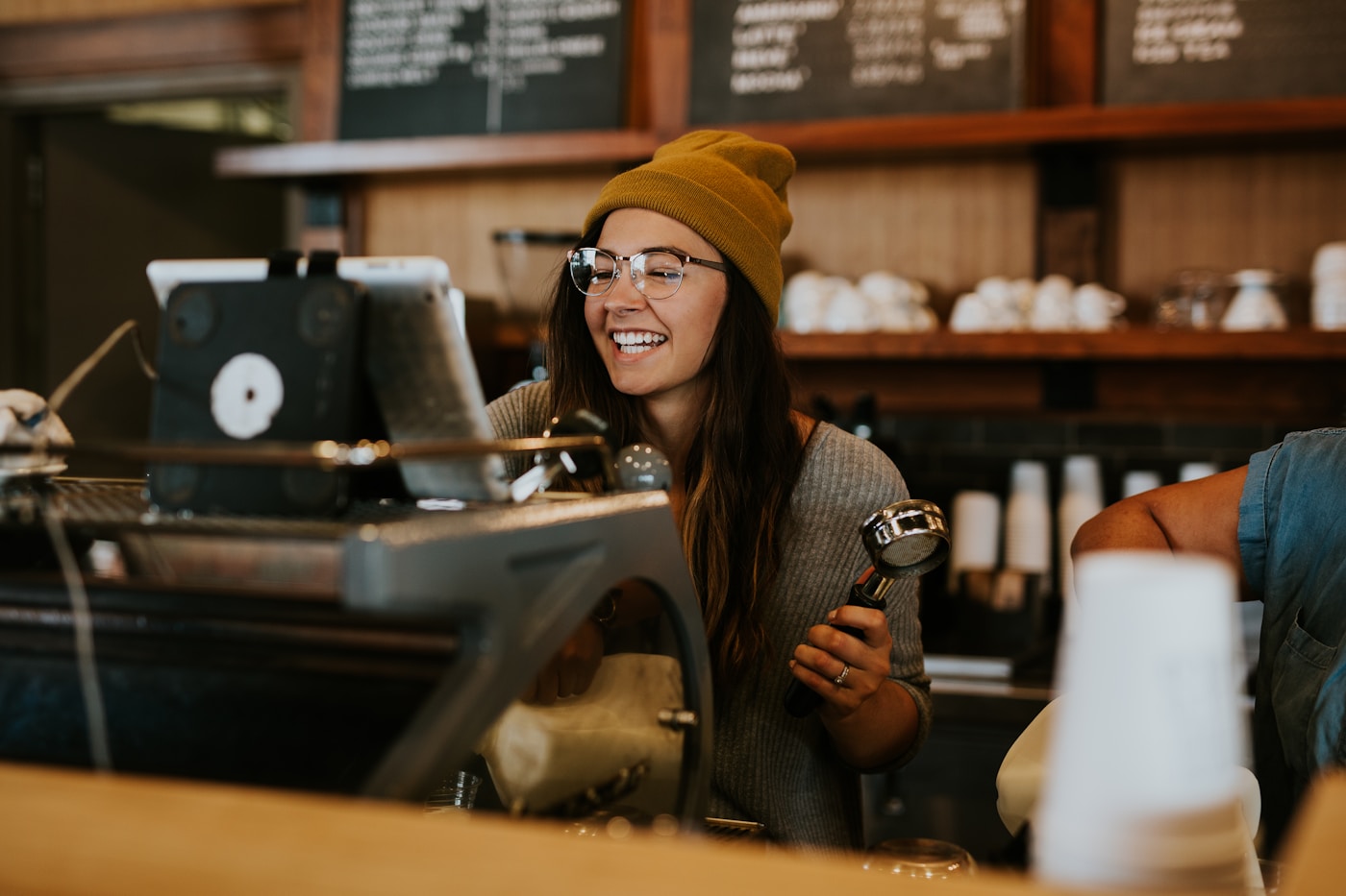 A smiling barista at work in a neighbourhood café